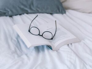 Book and spectacles on a bed