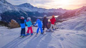 Group of children on skis look out on the view of the mountain
