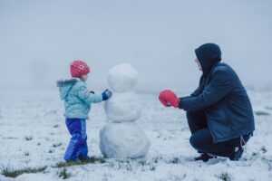 Father and child build a snowman